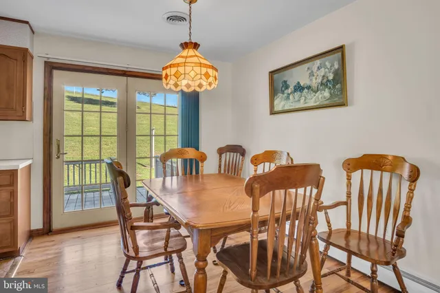 a view of a dining room with furniture a chandelier and wooden floor