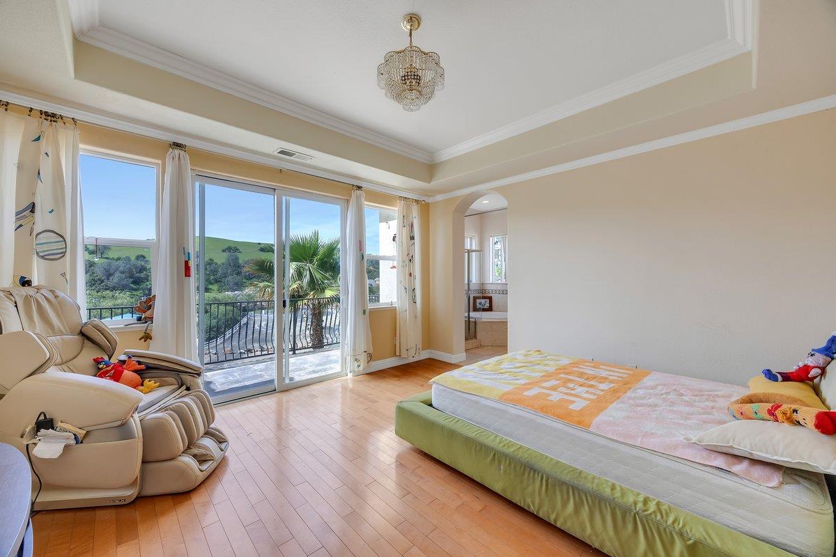 33 Aurora Lane Copperopolis, CA 95228 - Photo 21 of 46 bedroom featuring a raised ceiling, arched walkways, hardwood / wood-style floors, access to exterior, and crown molding