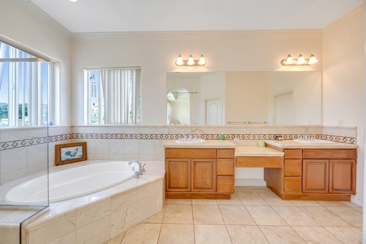 33 Aurora Lane Copperopolis, CA 95228 - Photo 23 of 46 bathroom with double vanity, crown molding, a bath, healthy amount of natural light, and light tile patterned floors