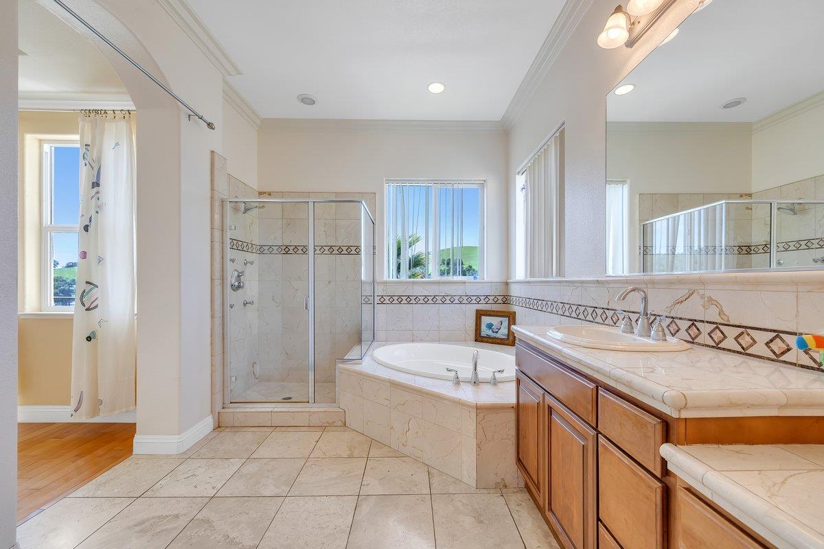 33 Aurora Lane Copperopolis, CA 95228 - Photo 27 of 46 bathroom featuring vanity, crown molding, a garden tub, a stall shower, and light tile patterned floors