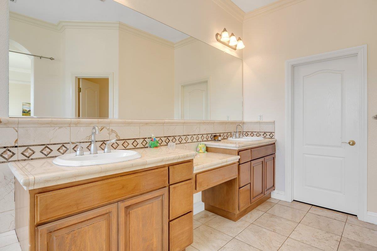 33 Aurora Lane Copperopolis, CA 95228 - Photo 28 of 46 bathroom with backsplash, double vanity, ornamental molding, and light tile patterned floors