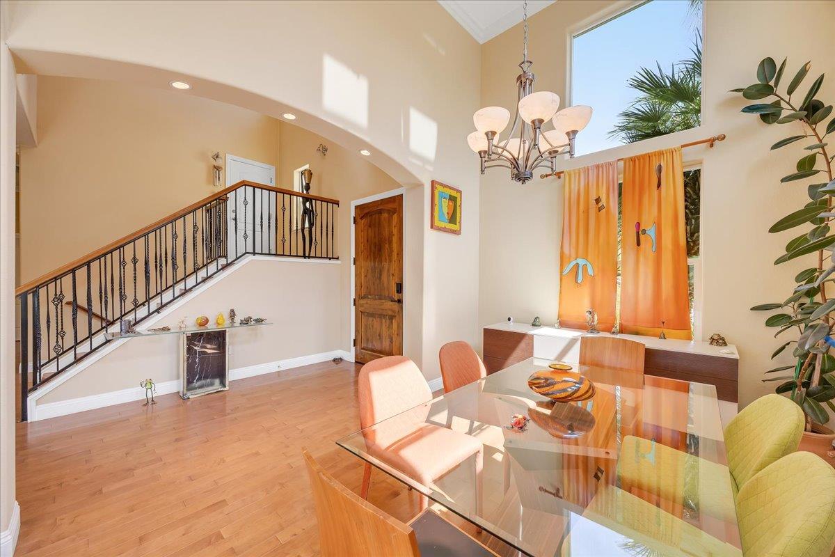 33 Aurora Lane Copperopolis, CA 95228 - Photo 6 of 46 dining area with light wood-type flooring, a chandelier, and a high ceiling