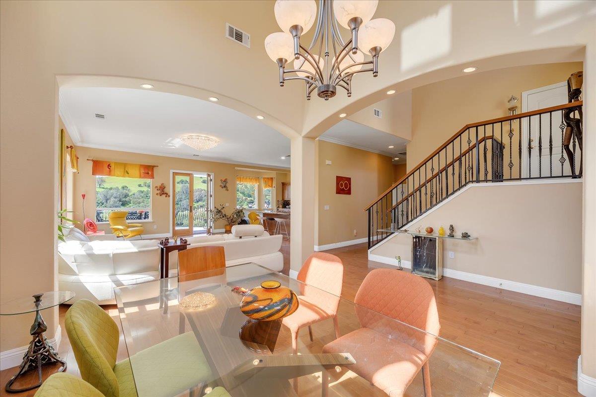33 Aurora Lane Copperopolis, CA 95228 - Photo 8 of 46 dining space featuring hanging lights, light wood-style floors, arched walkways, a high ceiling, and crown molding