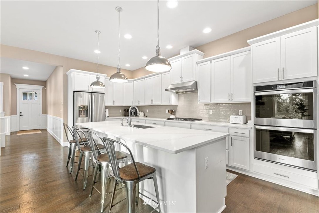 1416 242nd Place Southeast Bothell, WA 98021 - Photo 11 of 39 a kitchen with kitchen island a stove a table and chairs