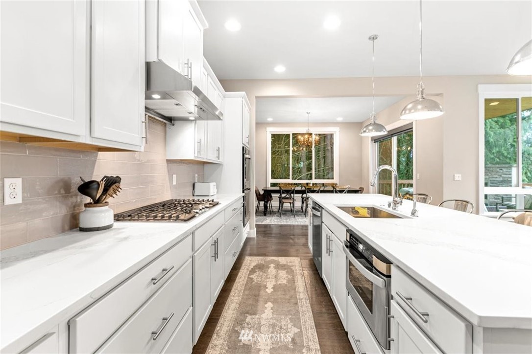 1416 242nd Place Southeast Bothell, WA 98021 - Photo 17 of 39 a large kitchen with stainless steel appliances granite countertop a lot of counter space and wooden floors