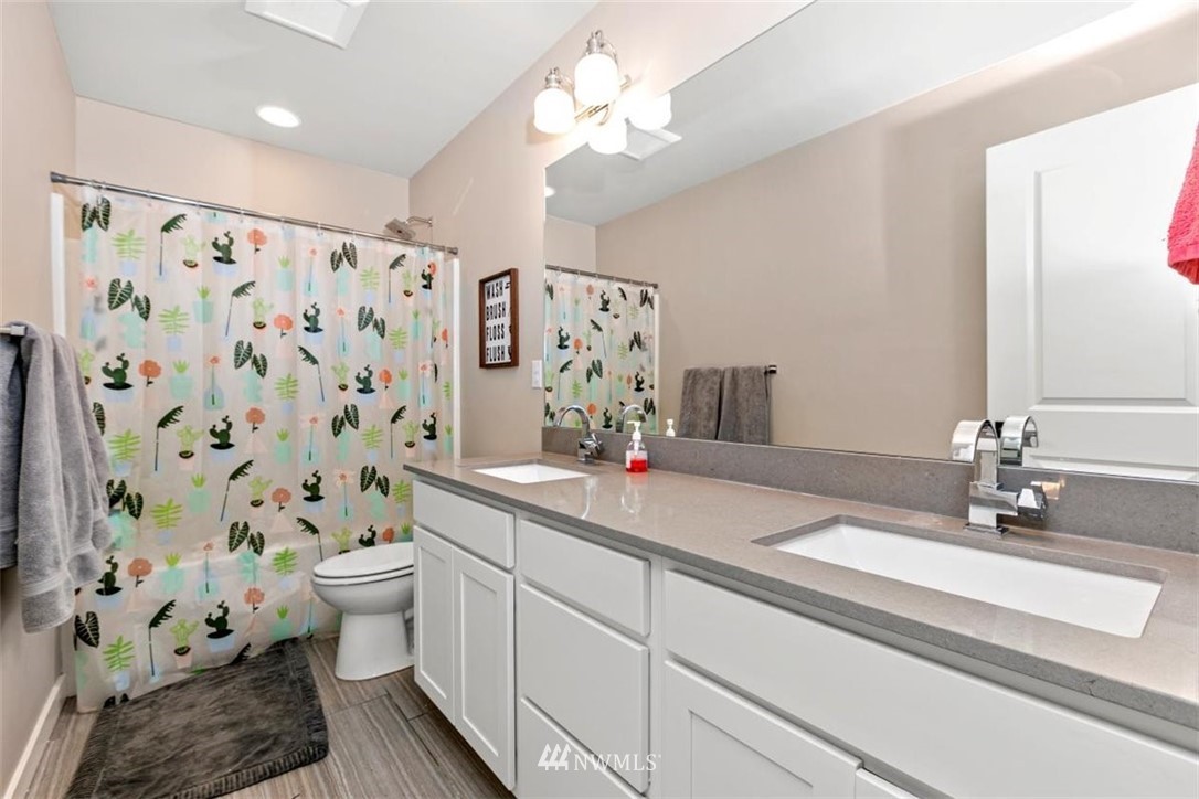 1416 242nd Place Southeast Bothell, WA 98021 - Photo 28 of 39 a bathroom with a sink a toilet and shower curtain