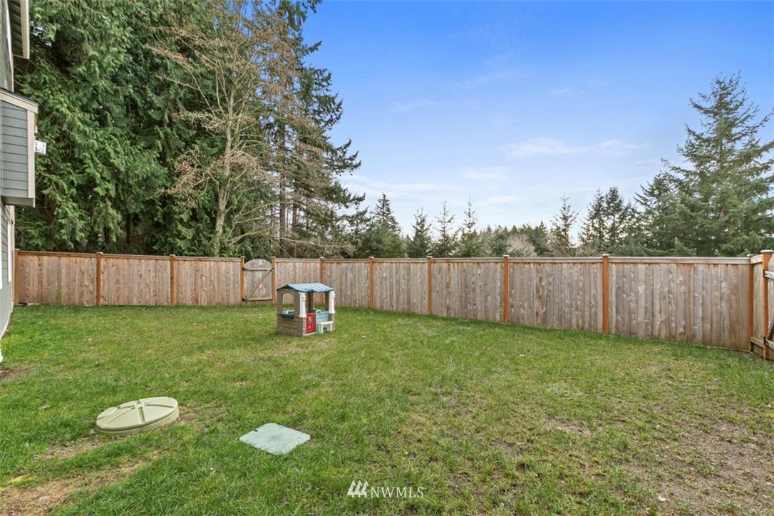 1416 242nd Place Southeast Bothell, WA 98021 - Photo 39 of 39 a view of a backyard with wooden fence and a bench