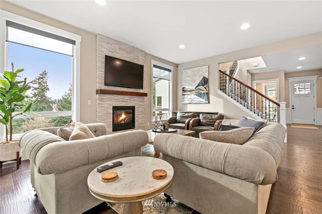 1416 242nd Place Southeast Bothell, WA 98021 - Photo 6 of 39 a living room with furniture a flat screen tv and a fireplace