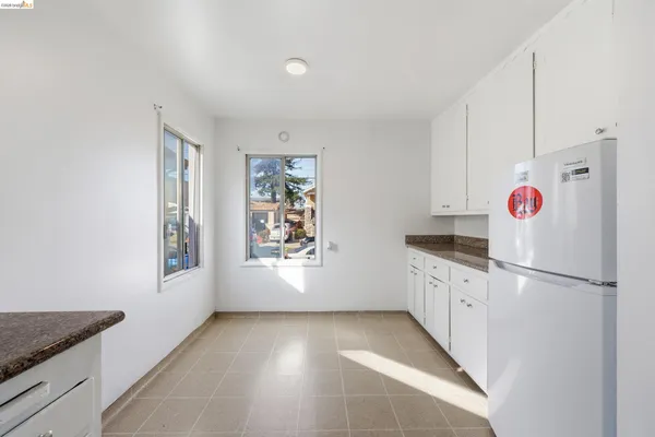 a kitchen with granite countertop a white refrigerator freezer and a stove