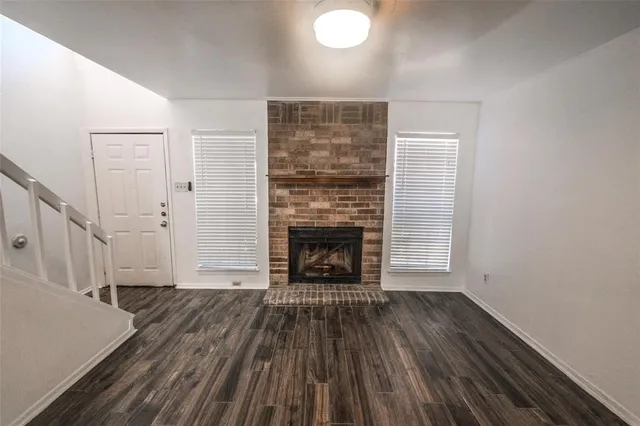 a view of a livingroom with wooden floor and a fireplace