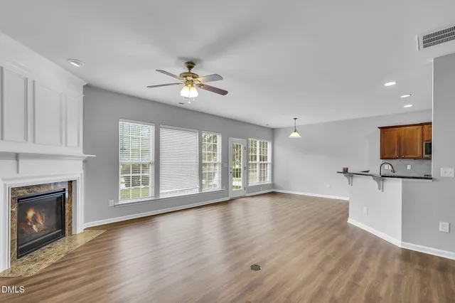 a view of an empty room with a fireplace and a window