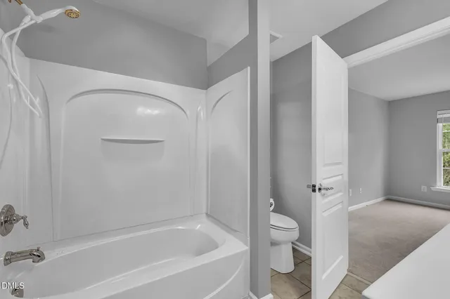 a spacious bathroom with a granite countertop toilet a sink and bathtub