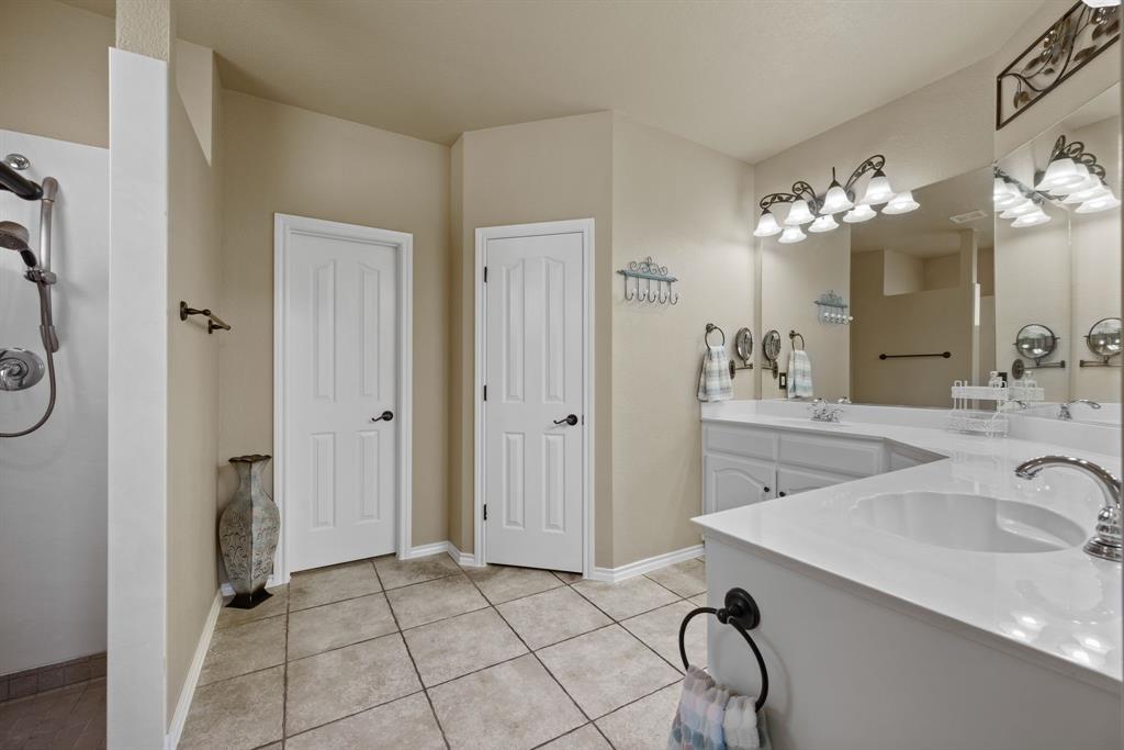 4172 Drexmore Road Fort Worth, TX 76244 - Photo 18 of 37 a spacious bathroom with a granite countertop sink a mirror and a shower
