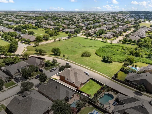 an aerial view of residential houses with outdoor space and lake view