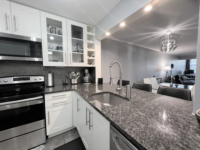 a kitchen with stainless steel appliances granite countertop a sink and stove