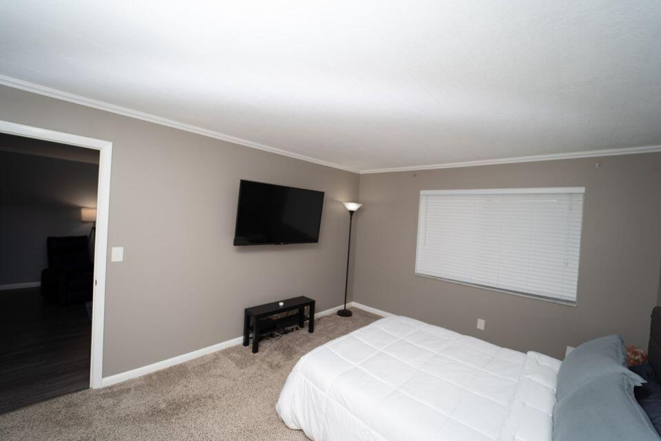 2920 Southwest 22nd Avenue, Unit 6040 Delray Beach, FL 33445 - Photo 13 of 53 a bedroom with a bed and a flat screen tv