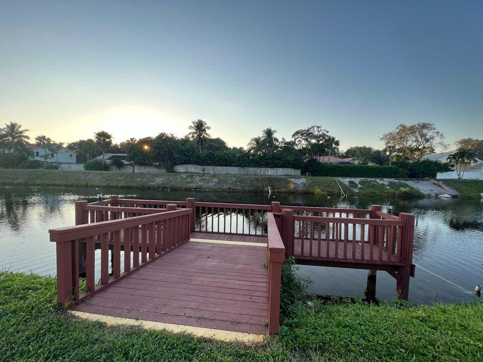 2920 Southwest 22nd Avenue, Unit 6040 Delray Beach, FL 33445 - Photo 17 of 53 a view of a wooden deck with furniture and a lake view