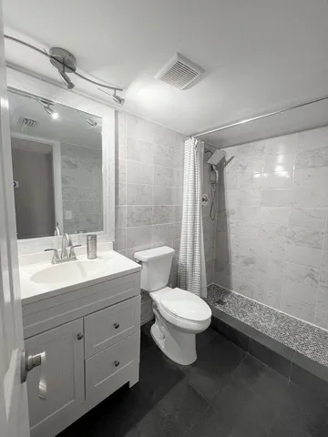 a bathroom with a double vanity sink toilet and shower
