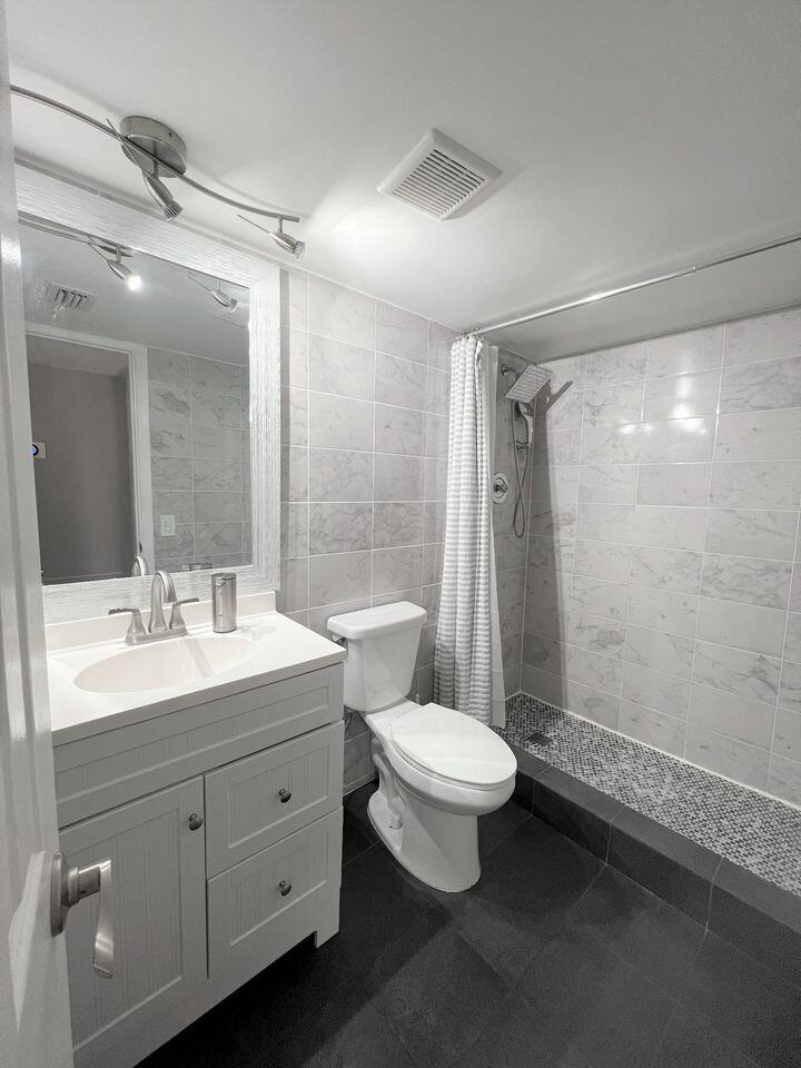 2920 Southwest 22nd Avenue, Unit 6040 Delray Beach, FL 33445 - Photo 2 of 53 a bathroom with a double vanity sink toilet and shower