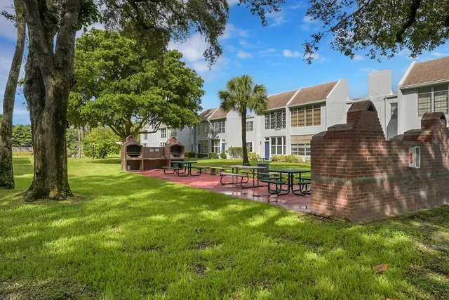 a kitchen with stainless steel appliances granite countertop a refrigerator a stove and white cabinets with wooden floor