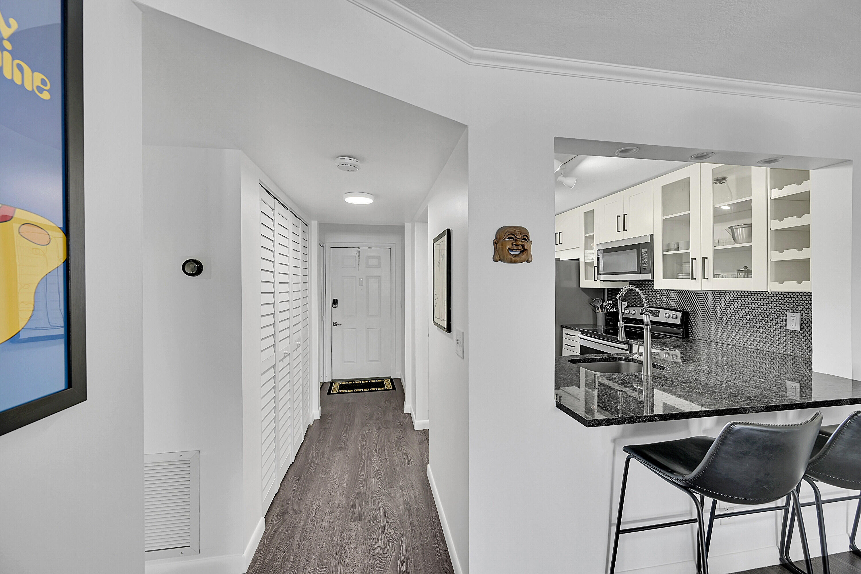 2920 Southwest 22nd Avenue, Unit 6040 Delray Beach, FL 33445 - Photo 32 of 53 a kitchen with stainless steel appliances granite countertop a refrigerator a stove and white cabinets with wooden floor