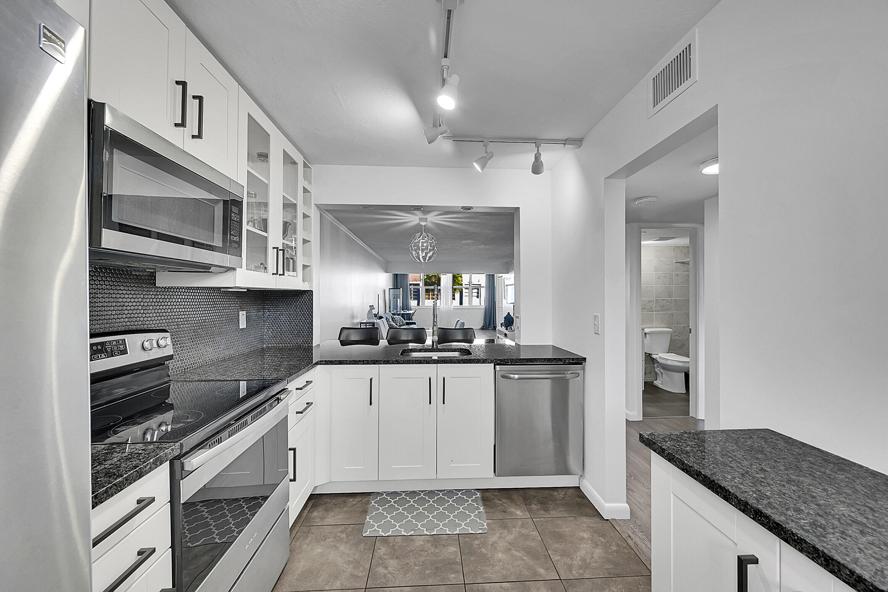 2920 Southwest 22nd Avenue, Unit 6040 Delray Beach, FL 33445 - Photo 34 of 53 a kitchen with stainless steel appliances granite countertop a sink and cabinets