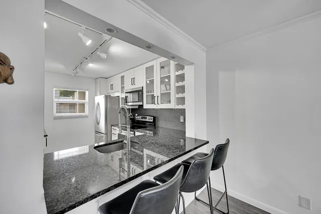 a view of swimming pool with outdoor seating and house in the background