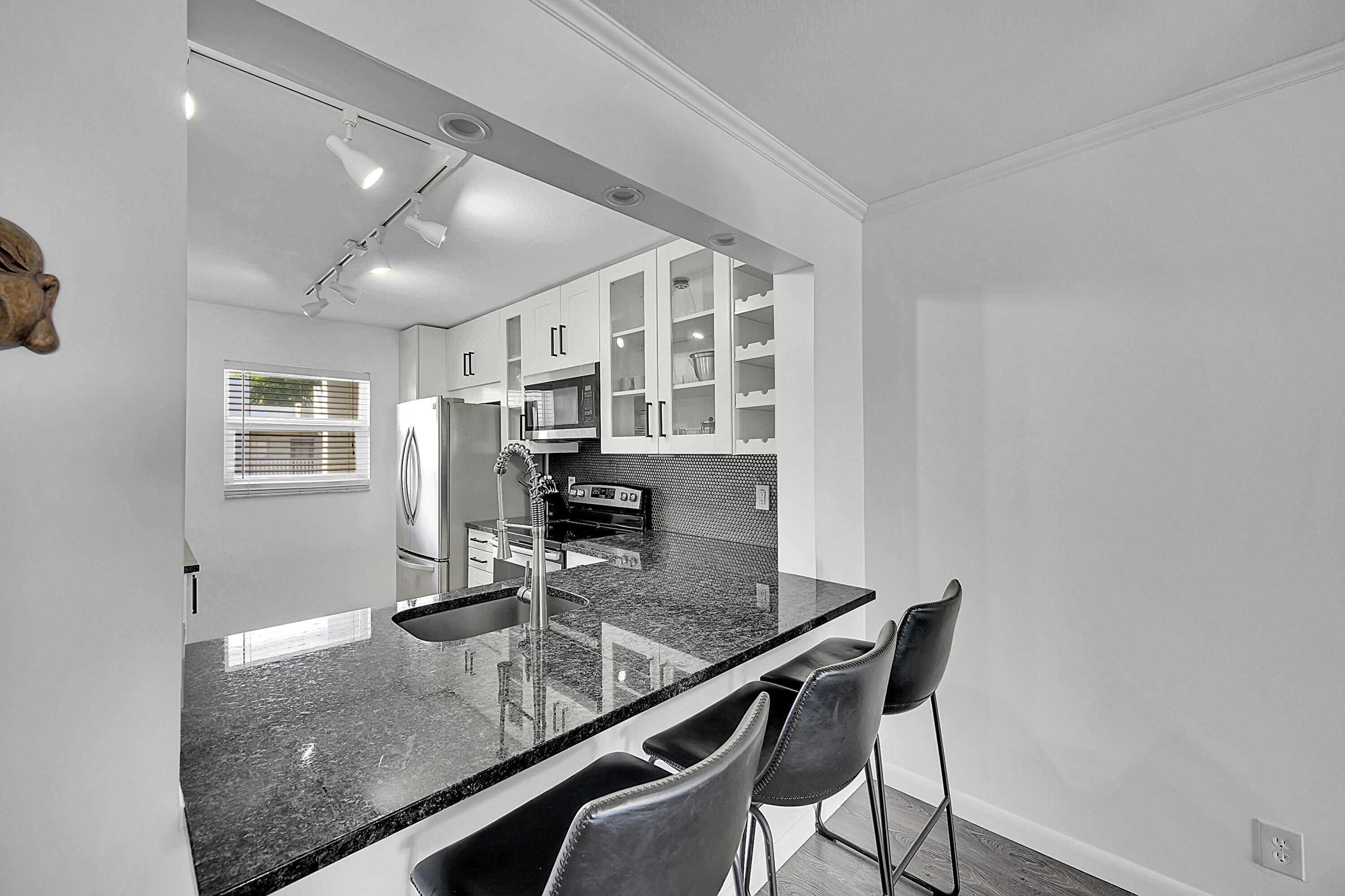 2920 Southwest 22nd Avenue, Unit 6040 Delray Beach, FL 33445 - Photo 36 of 53 a kitchen with a table chairs and microwave