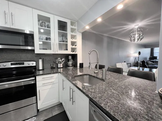 a kitchen with stainless steel appliances granite countertop a sink and stove