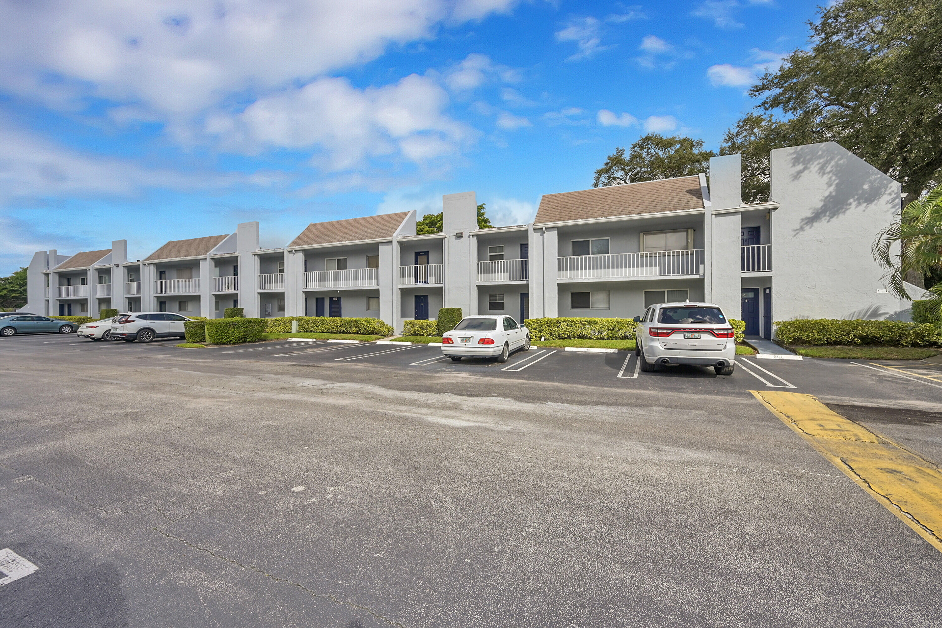 2920 Southwest 22nd Avenue, Unit 6040 Delray Beach, FL 33445 - Photo 43 of 53 a group of cars parked in front of a building