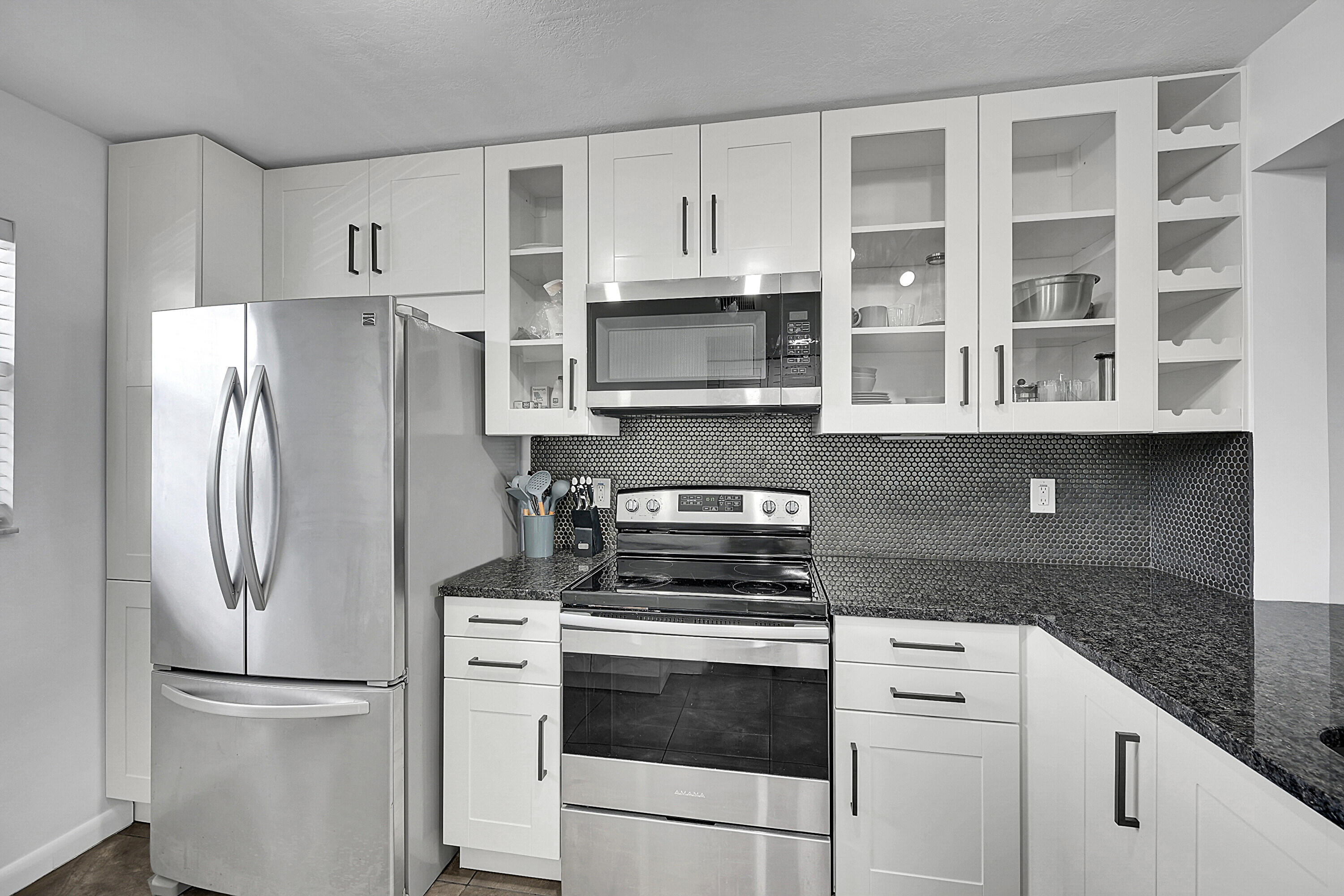 2920 Southwest 22nd Avenue, Unit 6040 Delray Beach, FL 33445 - Photo 48 of 53 a kitchen with stainless steel appliances white cabinets and a refrigerator