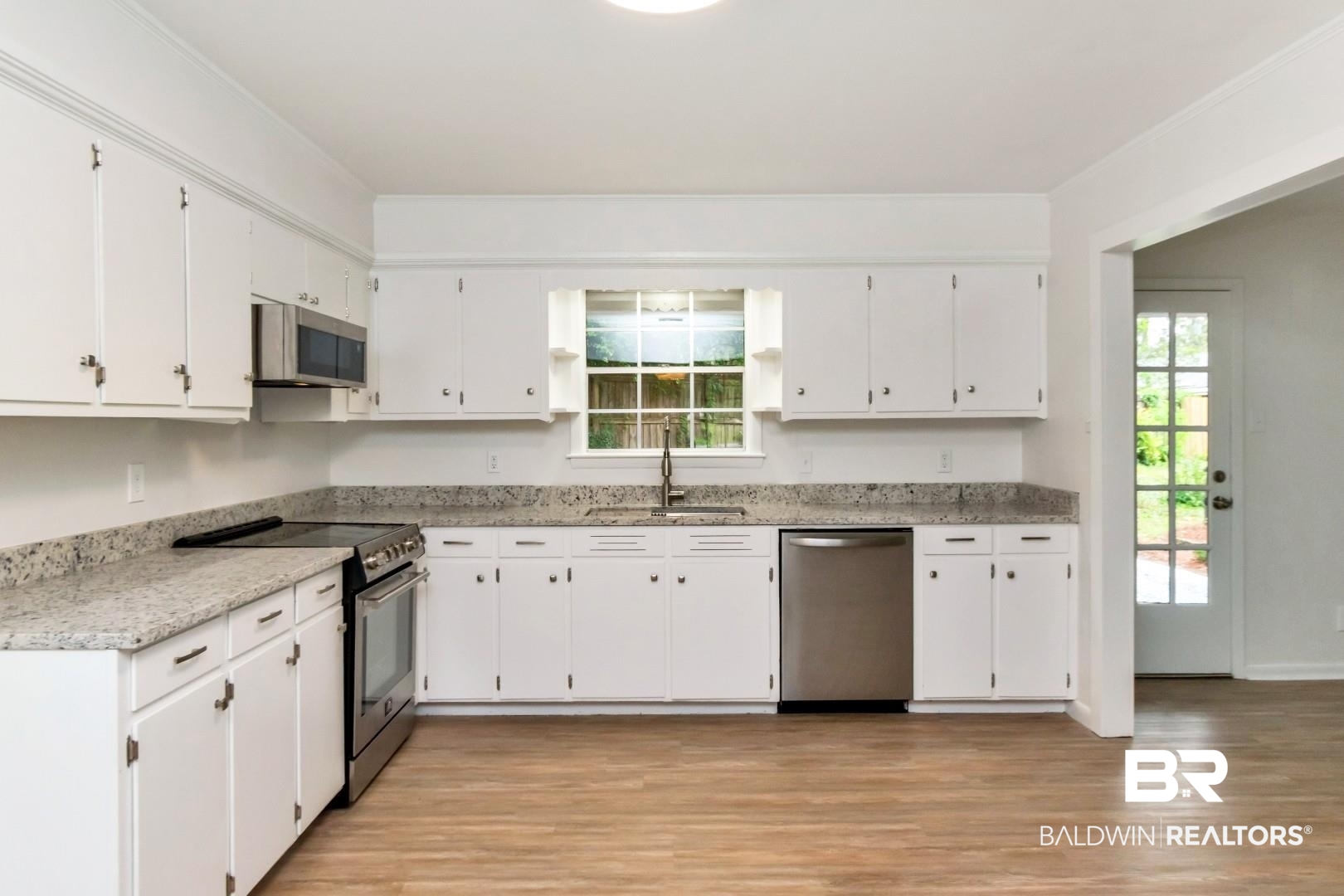 5217 Perin Road Mobile, AL 36693 - Photo 21 of 45 Kitchen featuring white cabinetry, light-toned countertops, and wood-finish flooring