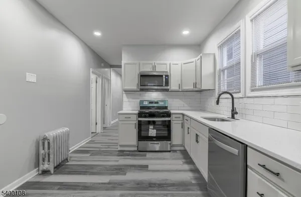 a kitchen with stainless steel appliances a stove sink and microwave