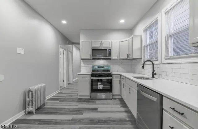 a kitchen with stainless steel appliances a stove sink and microwave