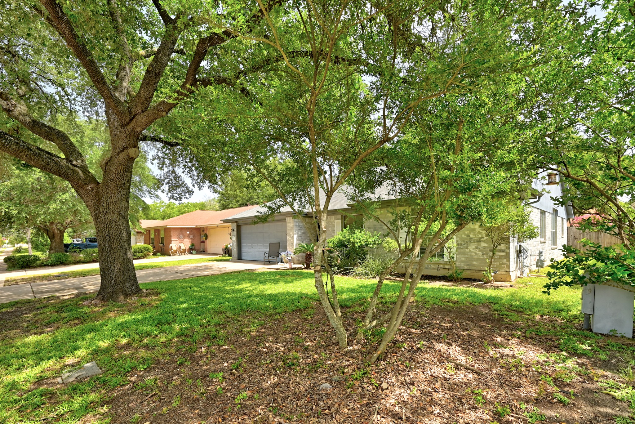 6412 Colton-Bluff Springs Road Austin, TX 78744 - Photo 2 of 27 Mature trees provide ample shade to the front lawn and stone-clad facade.