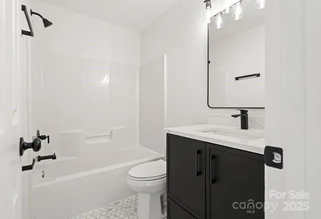 a bathroom with a sink a toilet a mirror a vanity and shower