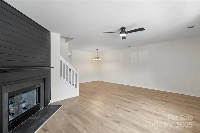 an empty room with windows and fireplace