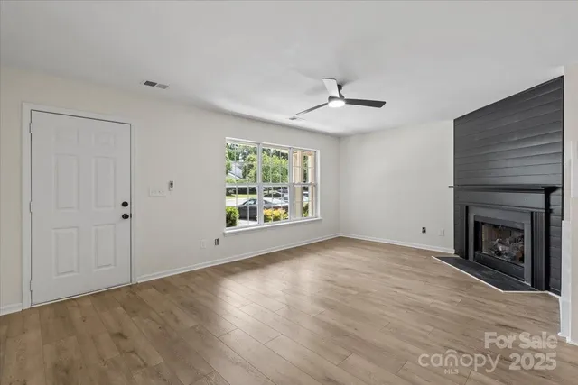 a view of an empty room with a window and fireplace