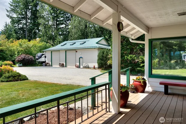 a view of a patio with table and chairs potted plants with wooden floor and fence