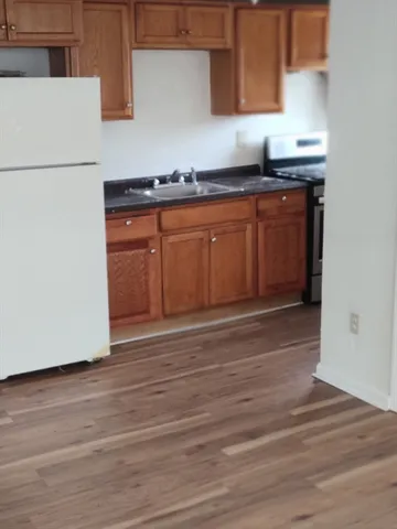 a kitchen with granite countertop wooden cabinets and a sink