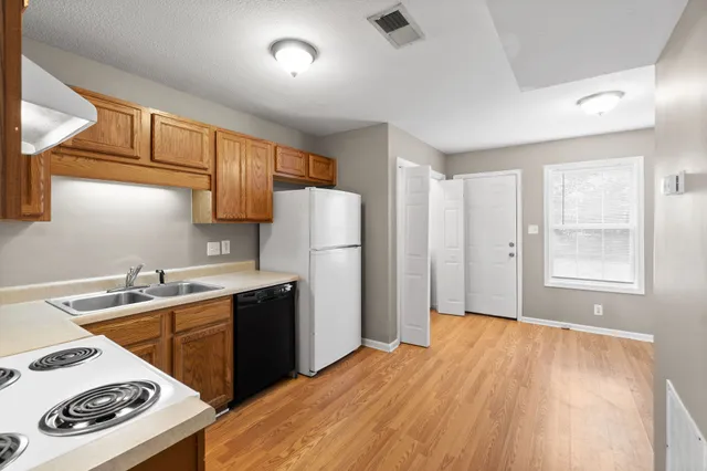 a kitchen with a sink a stove a refrigerator and cabinets