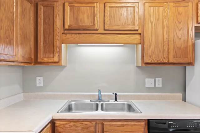 a kitchen with stainless steel appliances granite countertop a sink dishwasher and cabinets with wooden floor