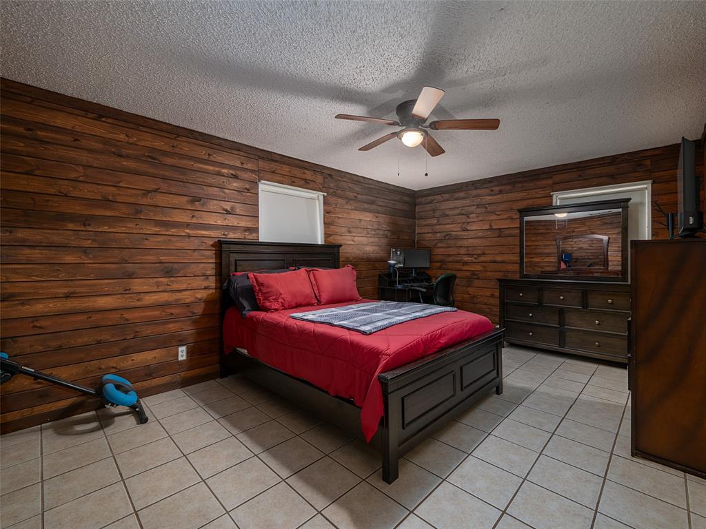 9663 Matise Street Tyler, TX 75706 - Photo 9 of 15 a bedroom with a bed and a flat tv screen on dresser