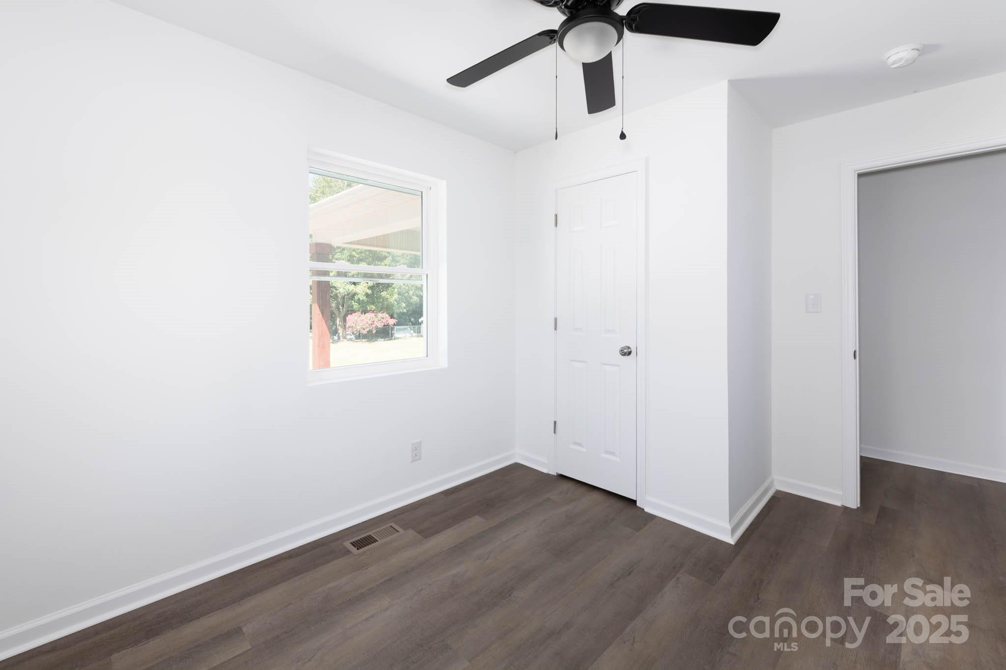 108 South Little Texas Road Kannapolis, NC 28083 - Photo 5 of 24 an empty room with wooden floor ceiling fan and windows