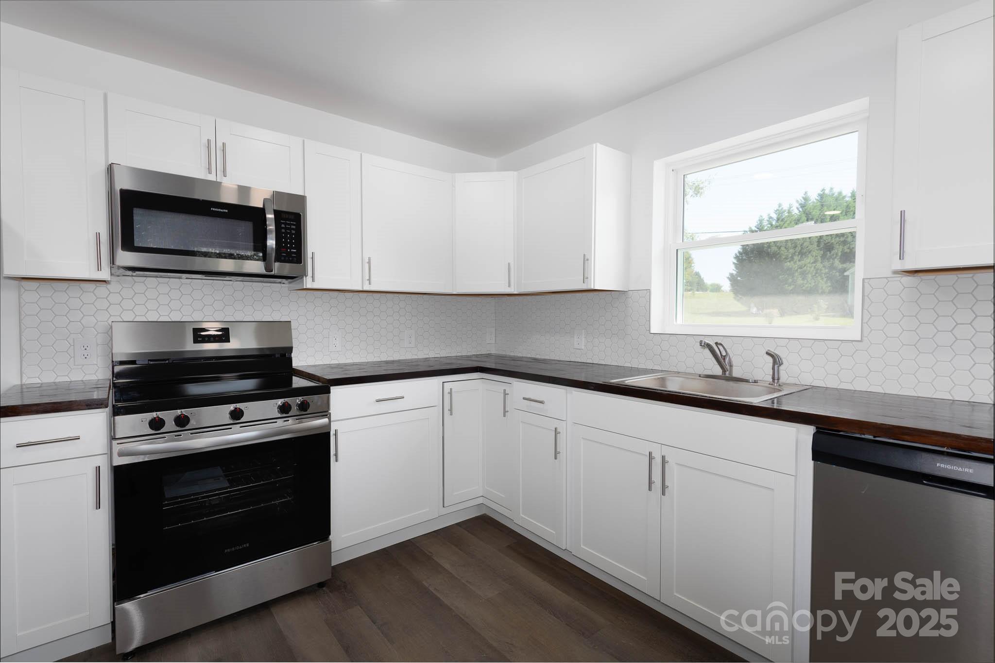 108 South Little Texas Road Kannapolis, NC 28083 - Photo 6 of 24 a kitchen with stainless steel appliances granite countertop grey cabinets a sink and a stove