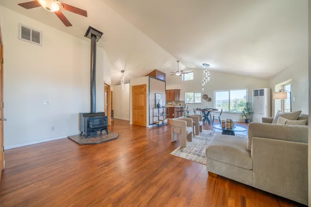 a living room with furniture large window and wooden floor