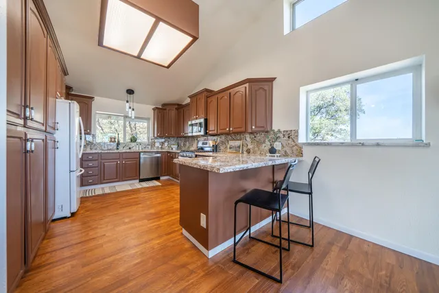 a kitchen with a refrigerator a sink and wooden cabinets