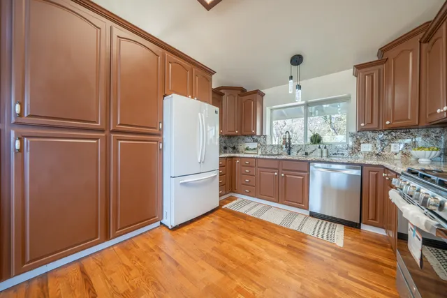 a kitchen with kitchen island wooden cabinets and stainless steel appliances