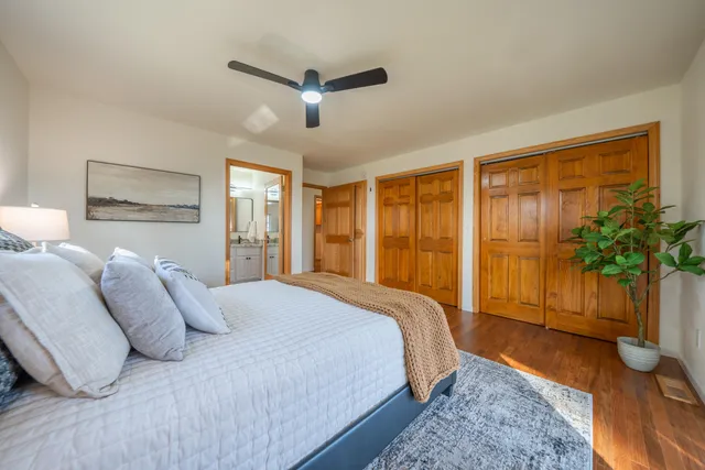 an empty room with wooden floor chandelier fan and closet area