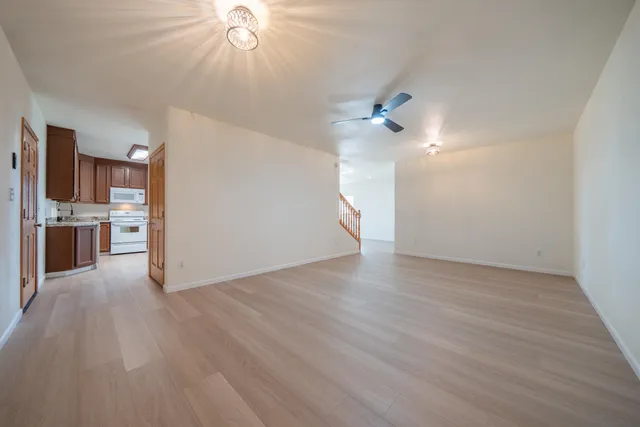 a kitchen with granite countertop a stove a sink and wooden floors